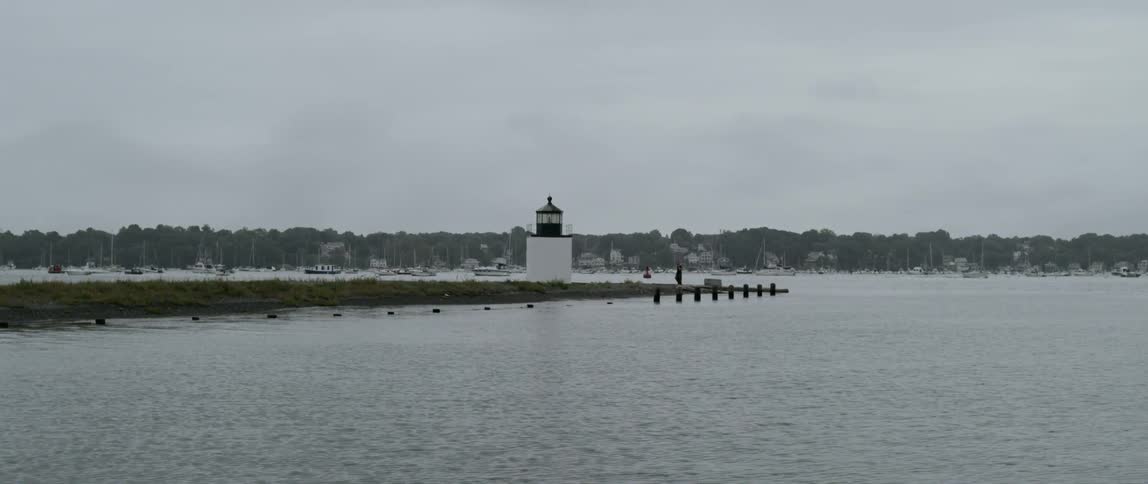 A light house is near the pier of the lake