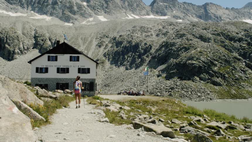 A woman hikes towards a mountain hut