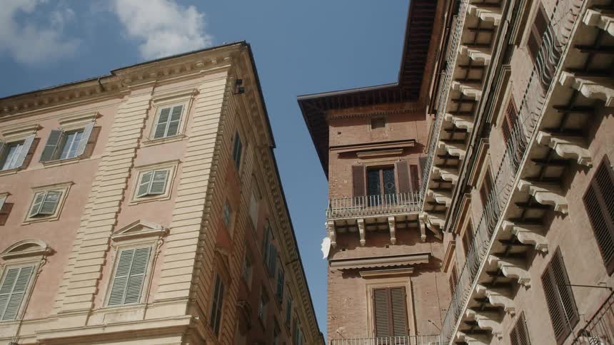 Two buildings with the sky and clouds above