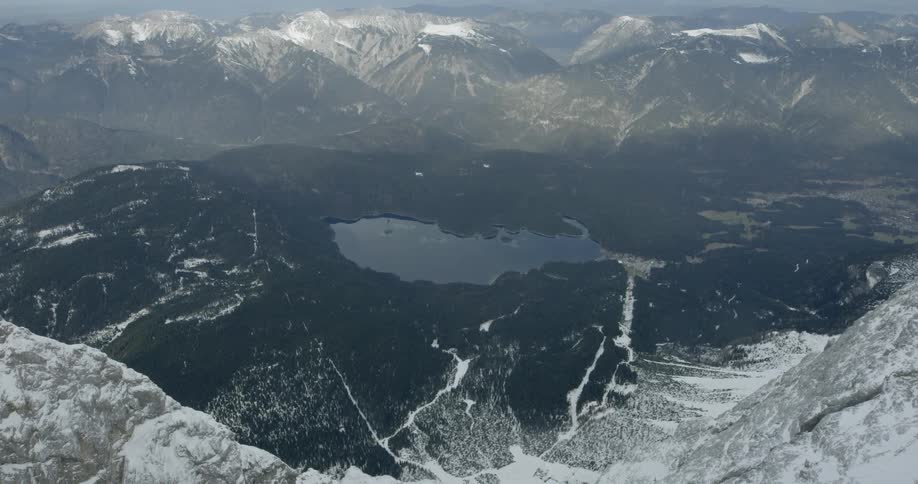 An aerial view of a lake in the middle of mountain range