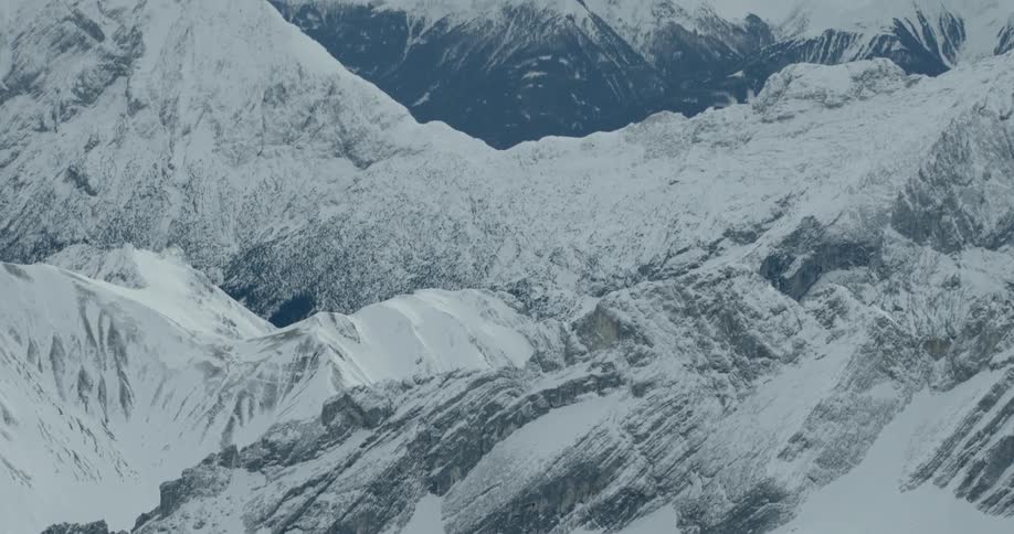 The large mountain range is covered in snow