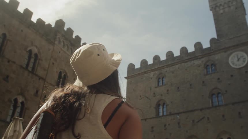 A female tourist with hat looking at the building around her