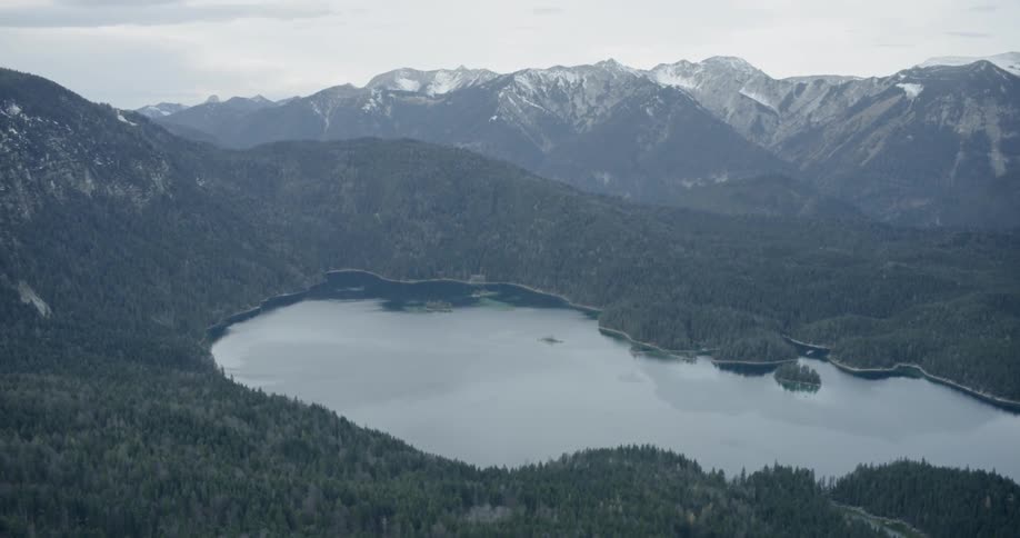 A lake between heavily forested mountain ranges