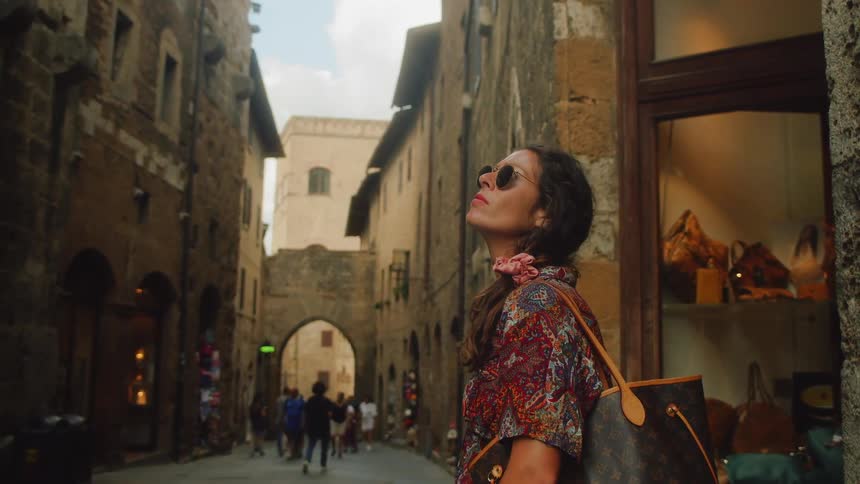 A young woman stands in the street and looks around