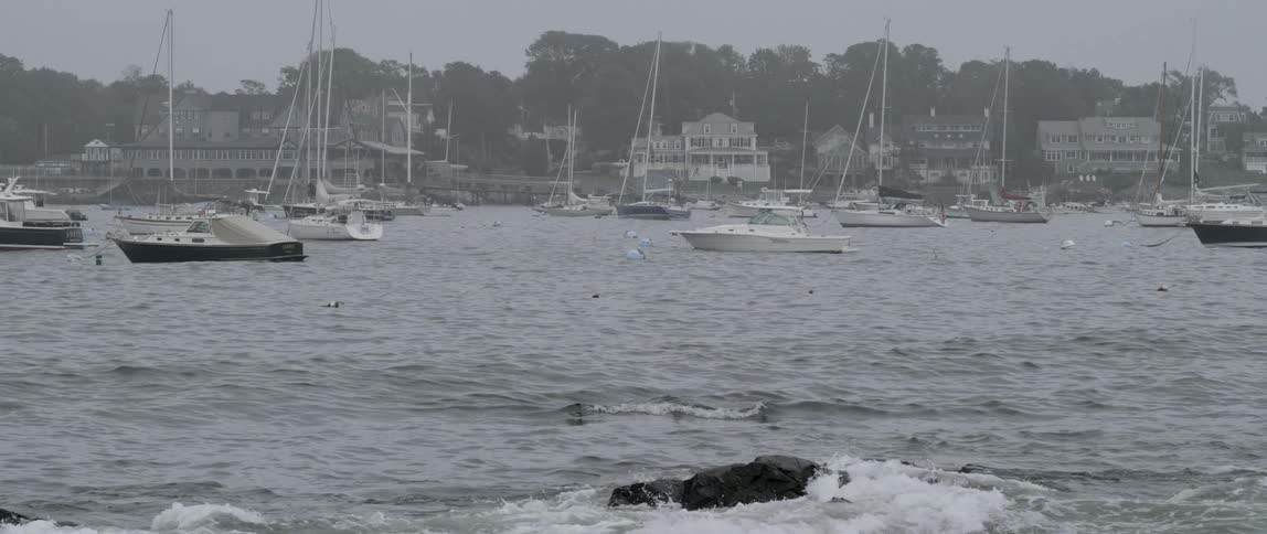 Boats sit in the water beside a coastal town