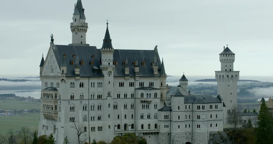 A large castle sits on a hillside