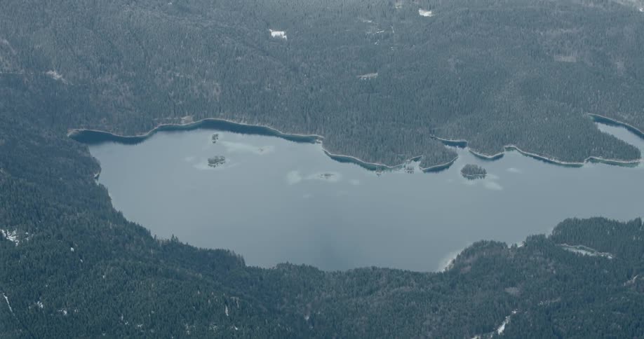 Aerial of black and white footage of large body of water surrounded by trees