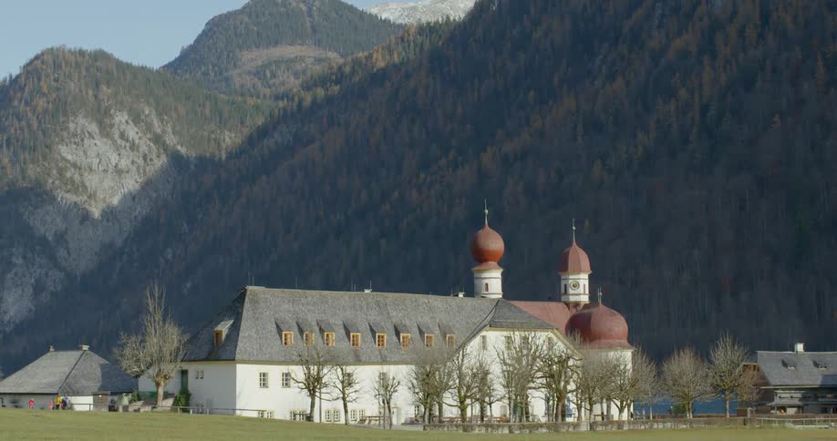 A church in a small village at the base of a mountain range