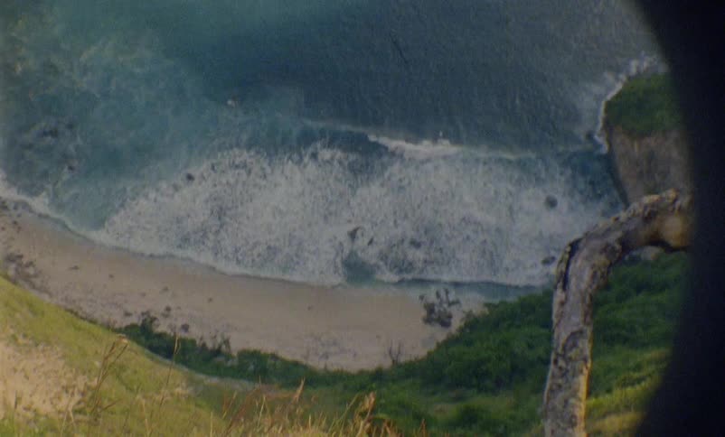 The sandy beach and waves in an ocean cove on a windy day