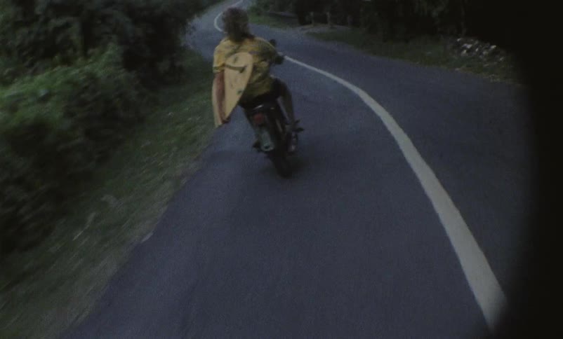 Man with yellow shirt riding a motorcycle