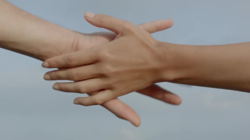Man and woman hold hands outdoors during daylight