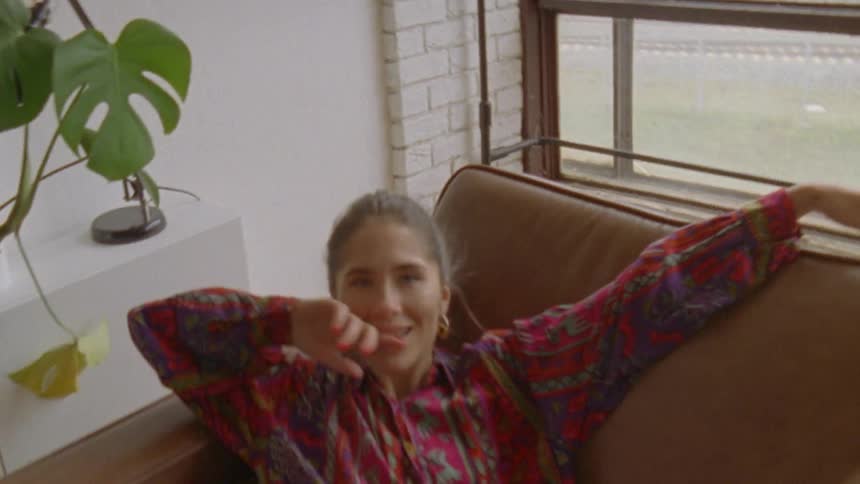 A woman flopping on a sofa and relaxing