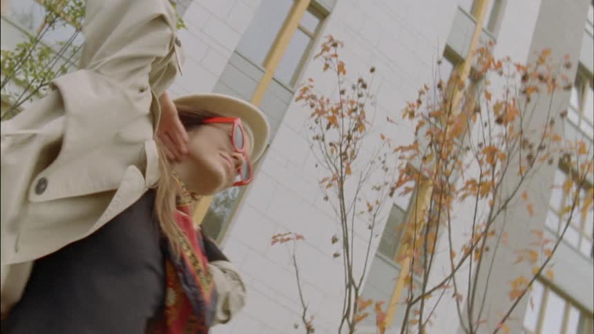 Woman with glasses and hat dancing in the downtown