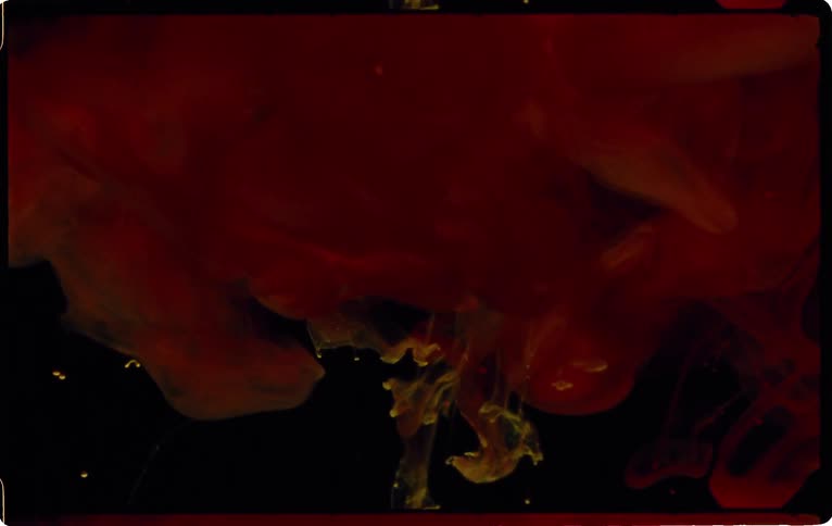 Red and yellow smoke roils downward until a flash of light appears highlighting the smoke