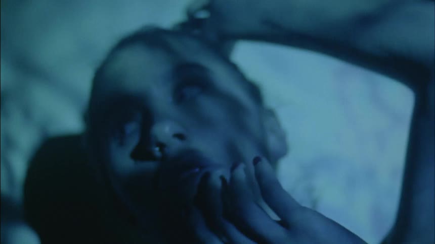 A woman being showered by light from projector