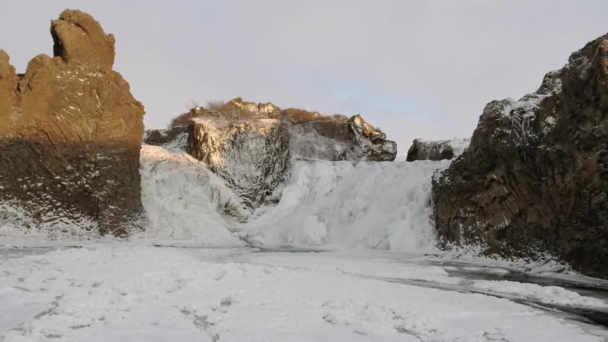 Snow falls and ice freezes in between cliffs