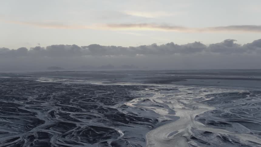 A frozen lake with the sky and the clouds in the background