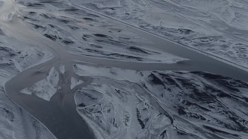 A series of rivers cut their way across a desolate and snow covered landscape