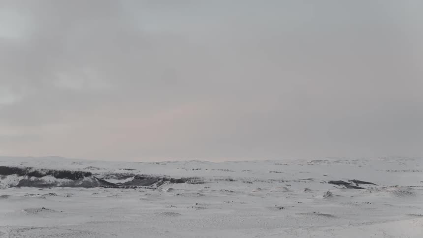A snowy tundra with the sky in the background