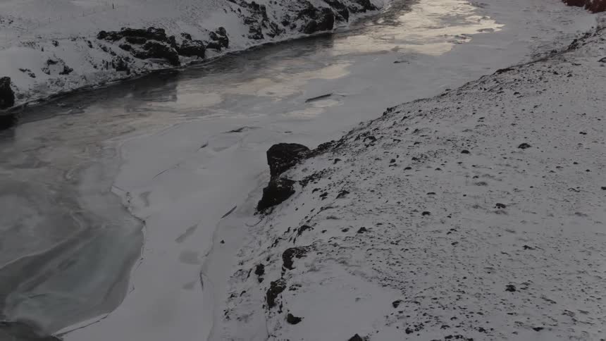A frozen river is covered with a layer of snow