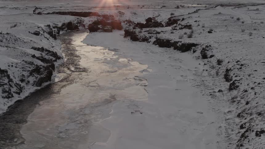 Snow hardens on top of a frozen river