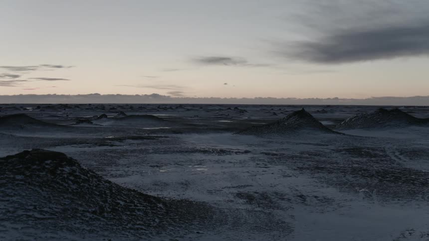 Snow covered hills are visible at dusk