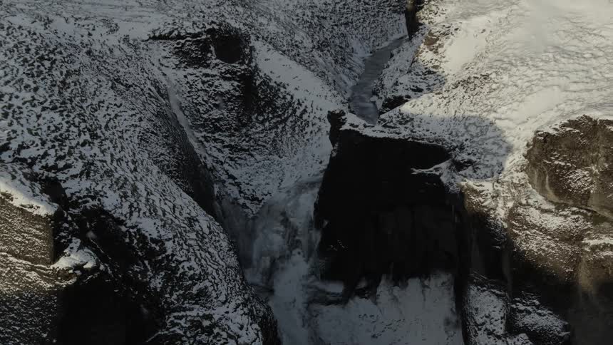 A frozen river runs through a snow covered mountain range
