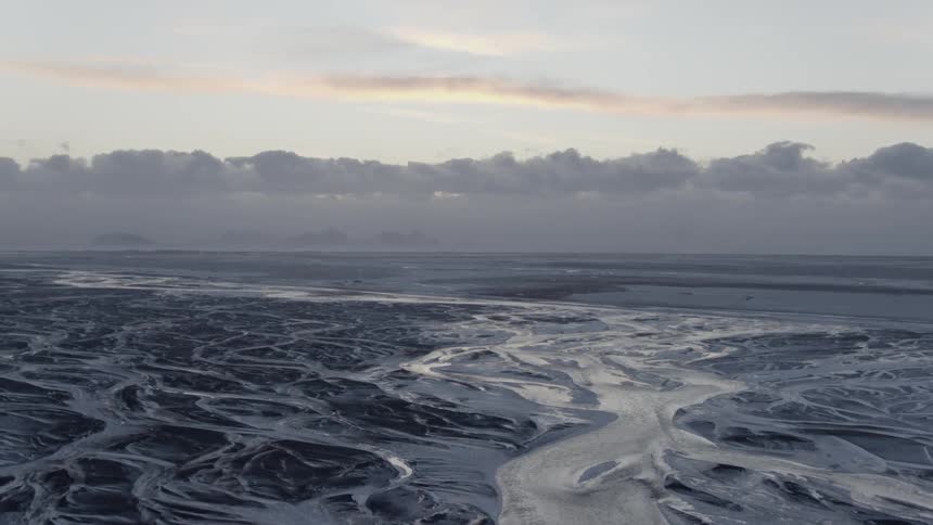 Frozen glossy terrain with heavy clouds on the horizon