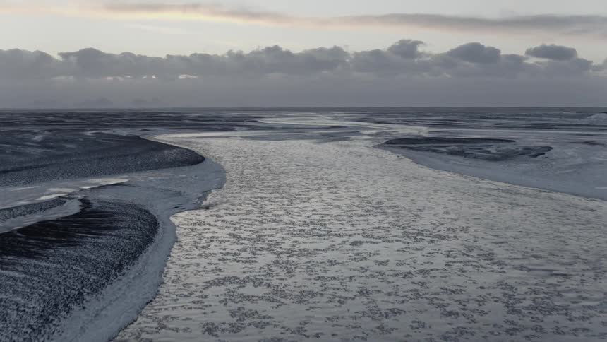 A river runs through a frozen landscape