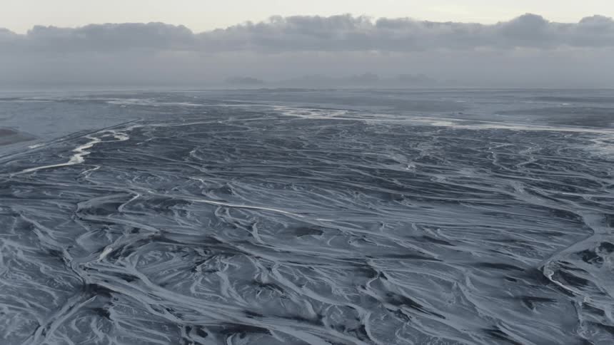 Streams of water flow over a frozen landscape