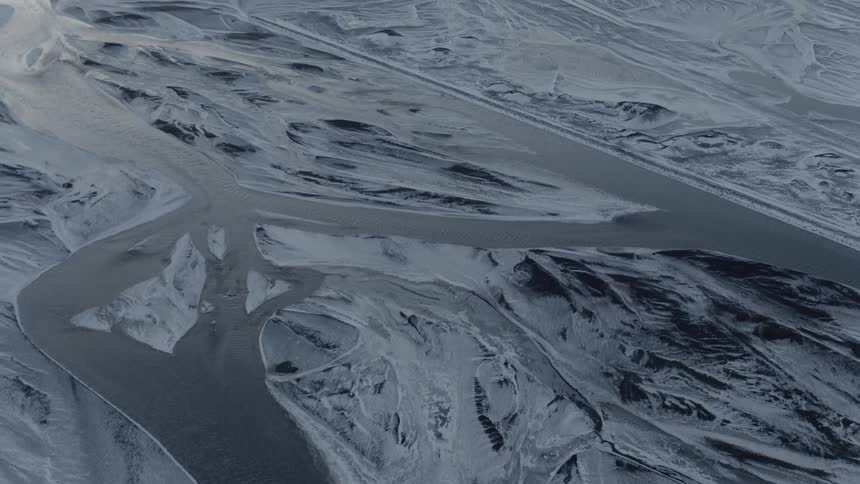 A light dusting of snow covers a frozen river