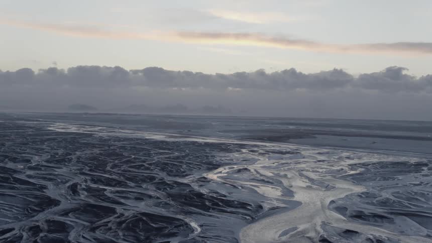 The wet sand below runs towards the ocean