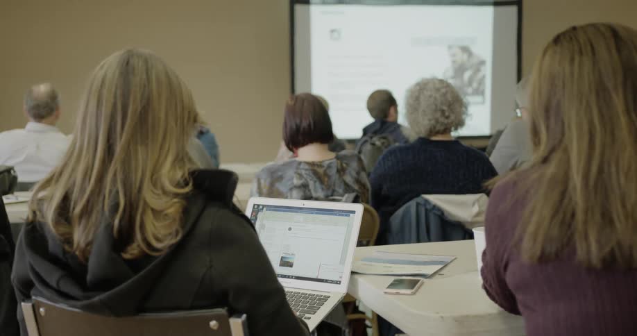 Students sit in classroom watching video