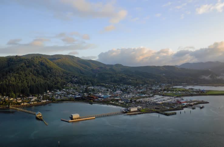 A harbor with a coastal town and mountains in the background
