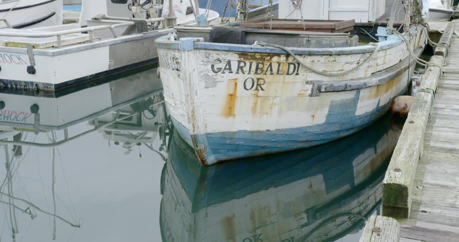 Small wooden boats float in a harbor by docks