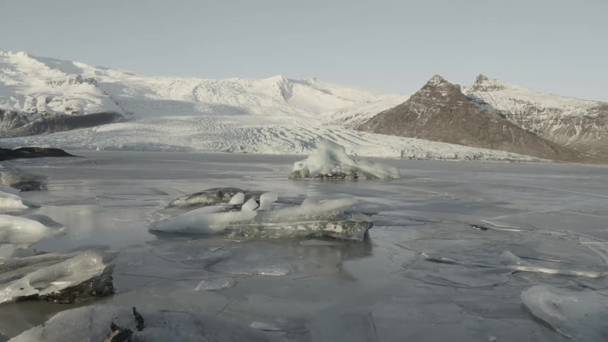Ice sits on a body of water at the tail of a glacier