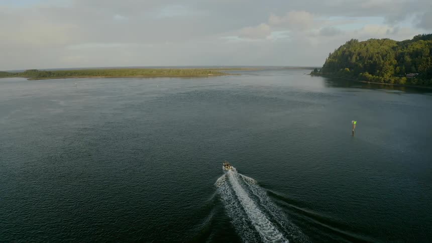 A speed boat traverses through a calm lake