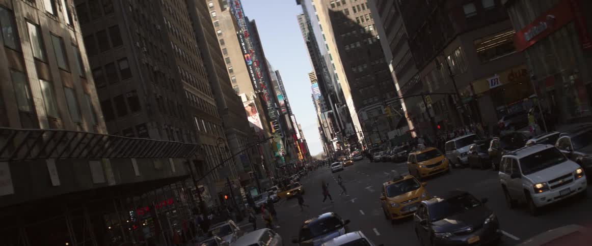 An elevated view of a long city street with tall buildings and traffic