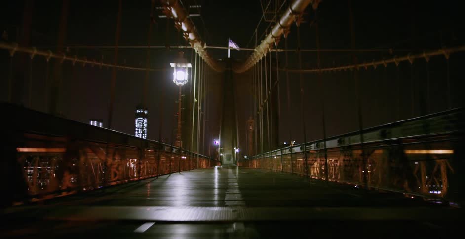 Traveling on a bridge at night heading towards the city lights