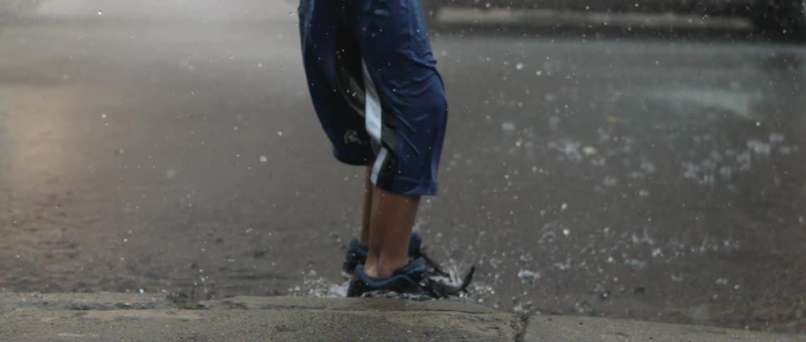 Water is spraying in an area as children play in slow motion
