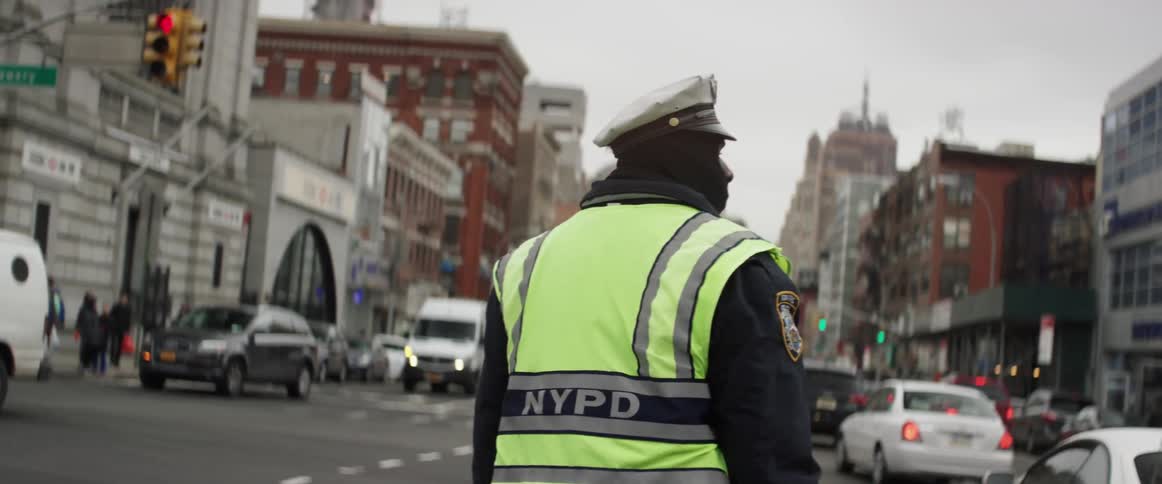 A police officer is directing traffic in a city on a cloudy day