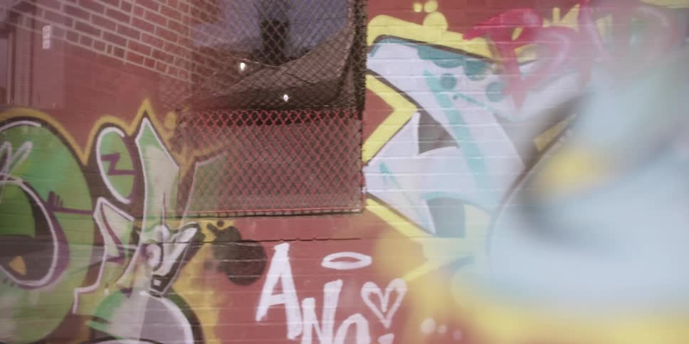 Colorful graffiti on a brick wall is broken up by a window