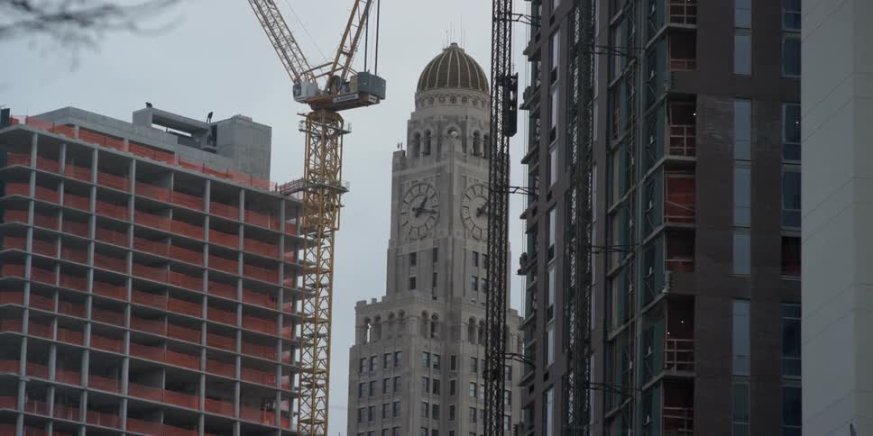 A large crane sits atop scaffolding in a city