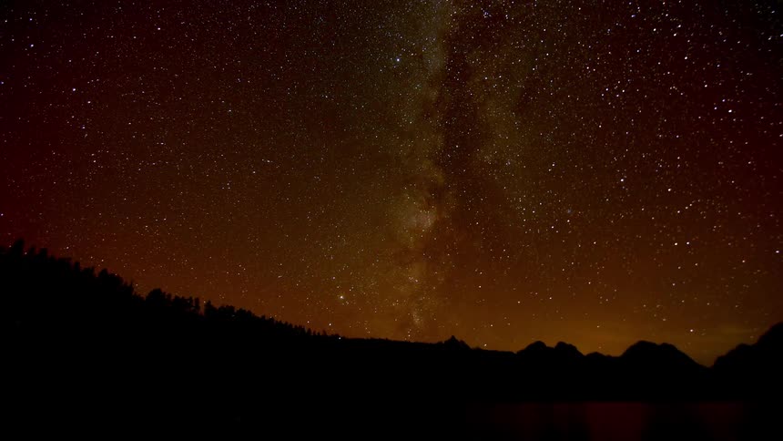 A lake with a starry sky in the background