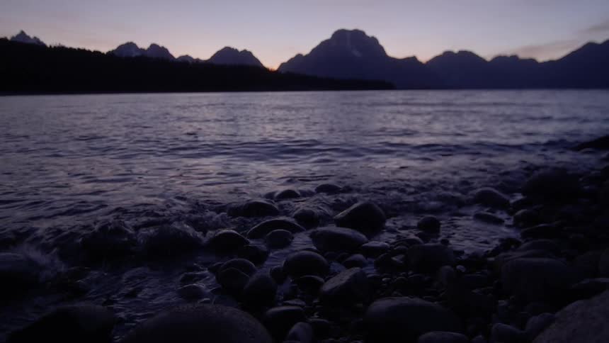 Lake water waves on a small rocky coast