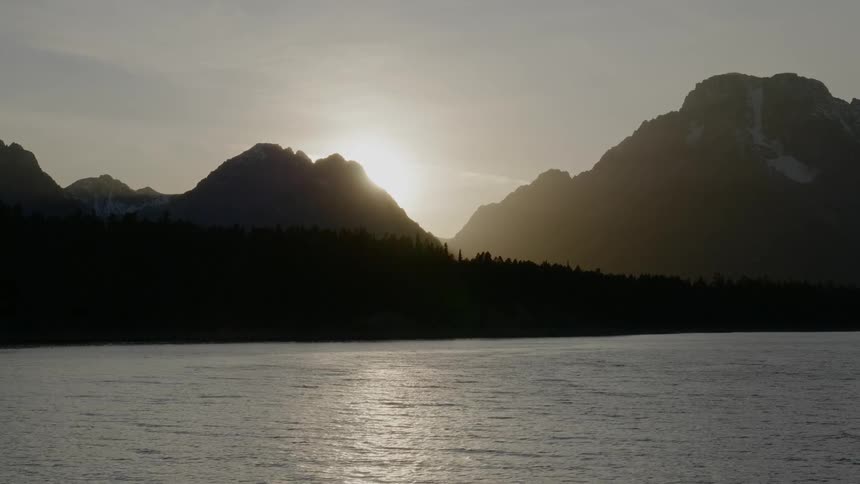 Landscape view of the sun peaking over the mountain top