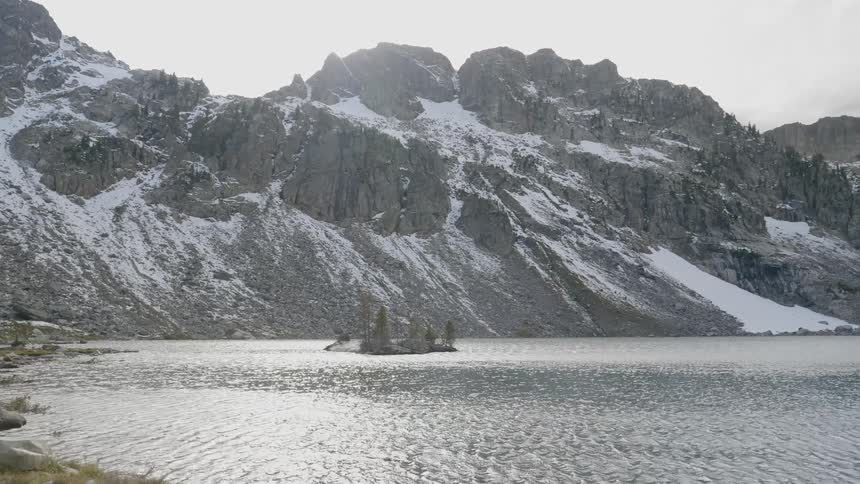 A lake in front of a snow covered mountain