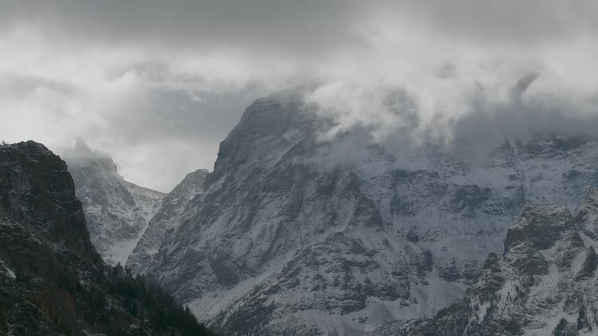 Dark clouds float over the snowy mountains