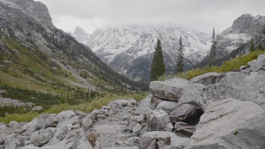 Stacks of rocks lead downhill to a mountain range
