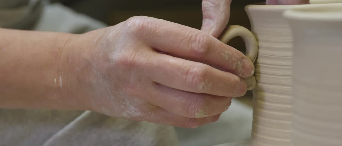 Person making a mug out of clay